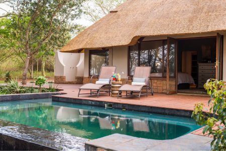 Villa with pool and relaxing chairs